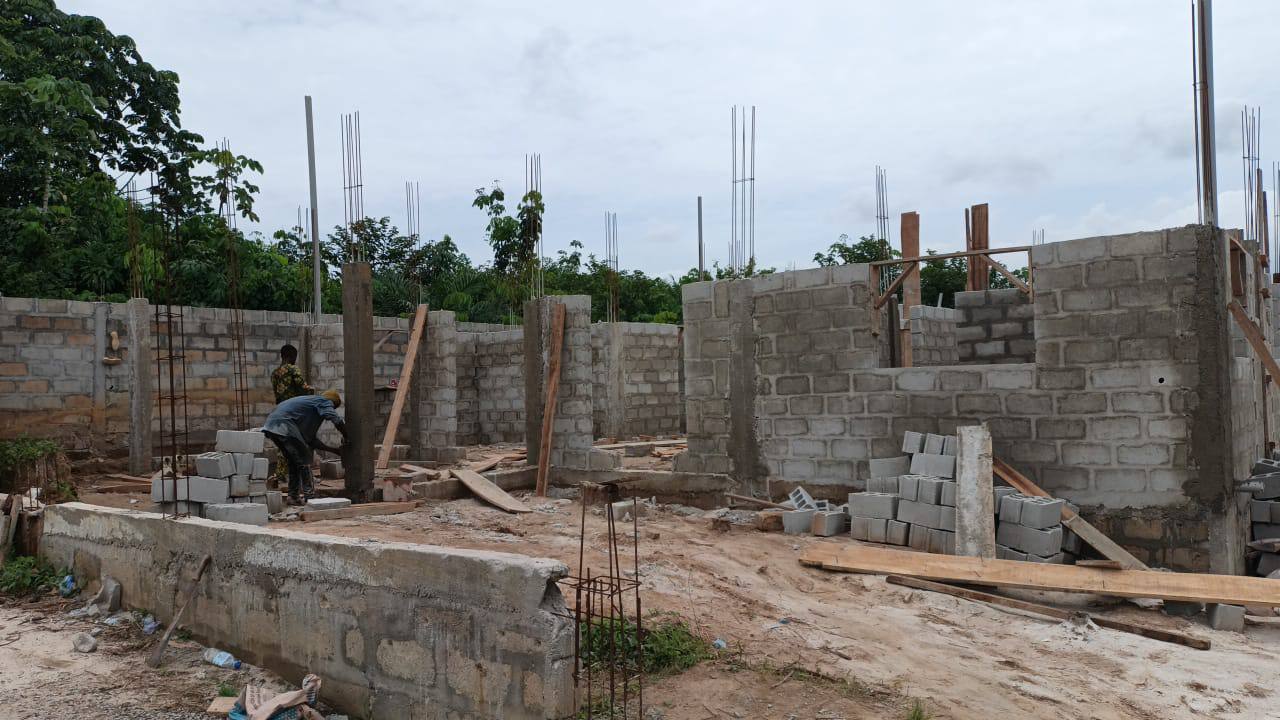 Chantier avec murs en blocs et equipe de maconnerie